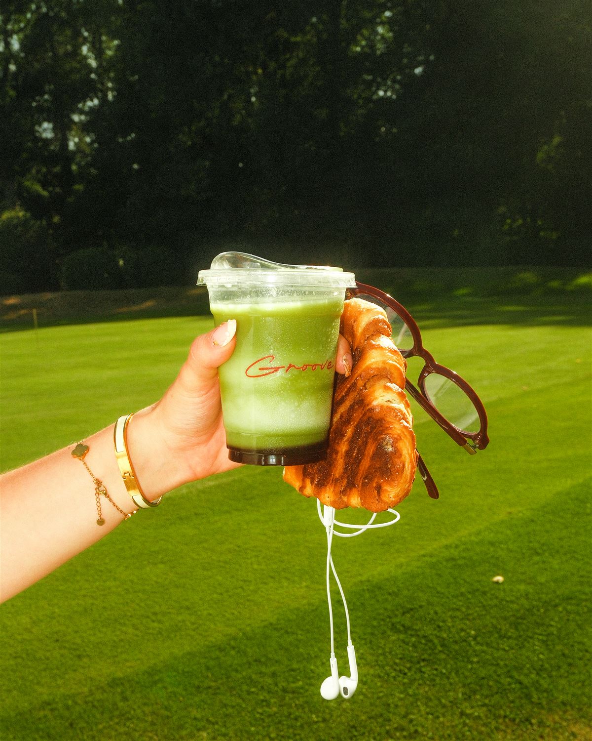Matcha Latte und Franzbrötchen in der Hand