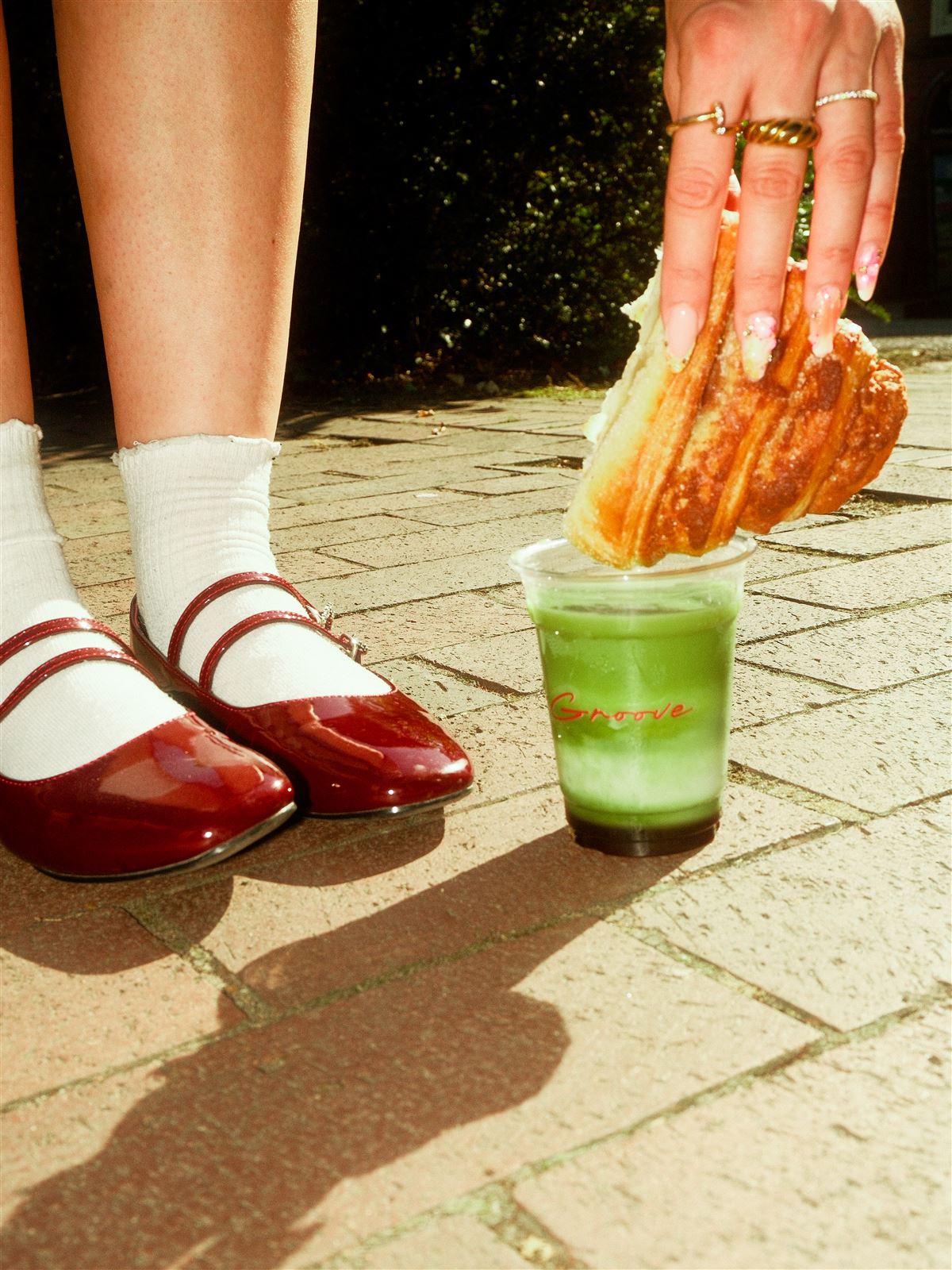 Franzbrötchen wird in einen Matcha Latte getunkt